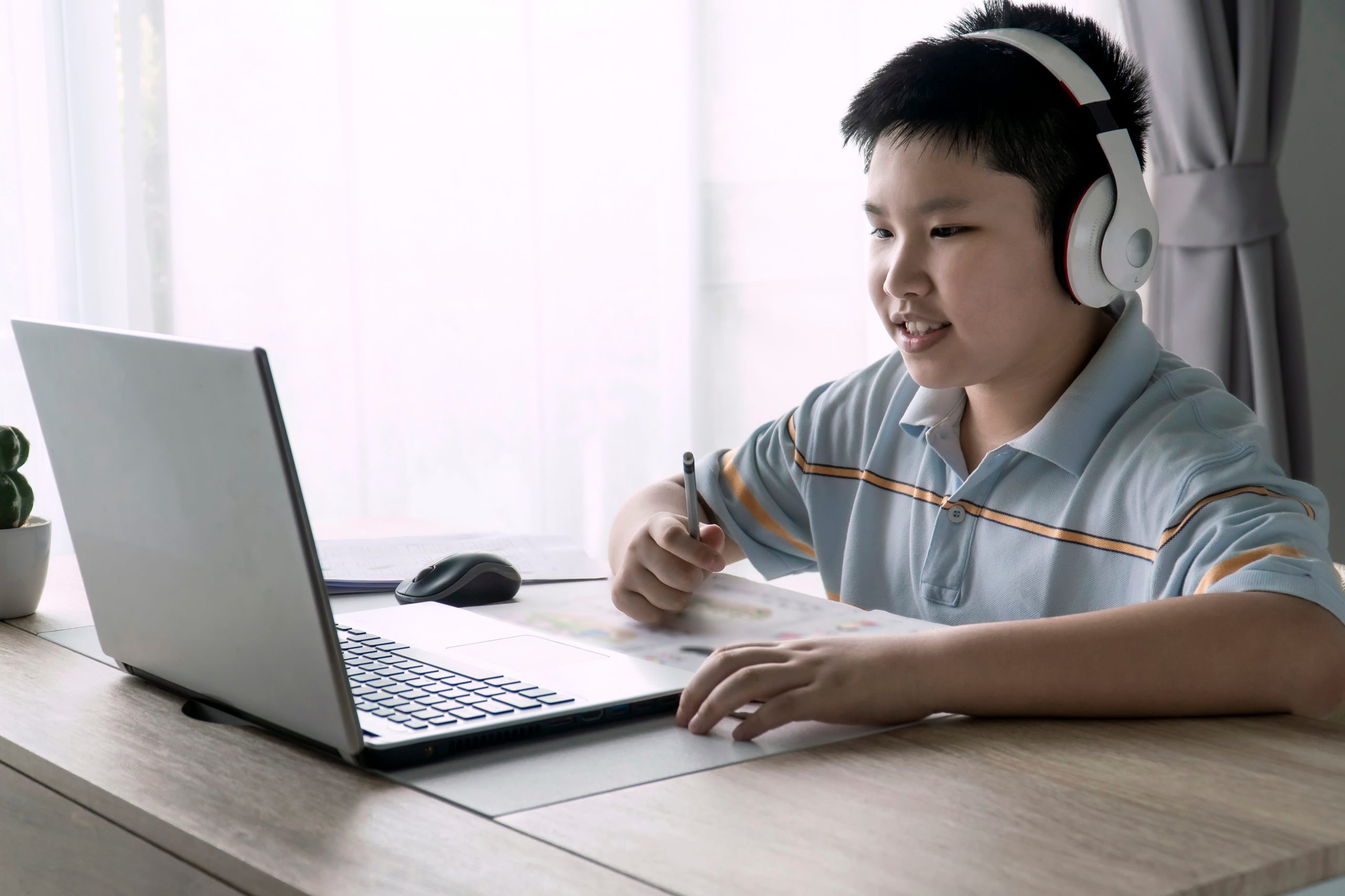 Asian Kid self isolation using laptop for his homework, Social D