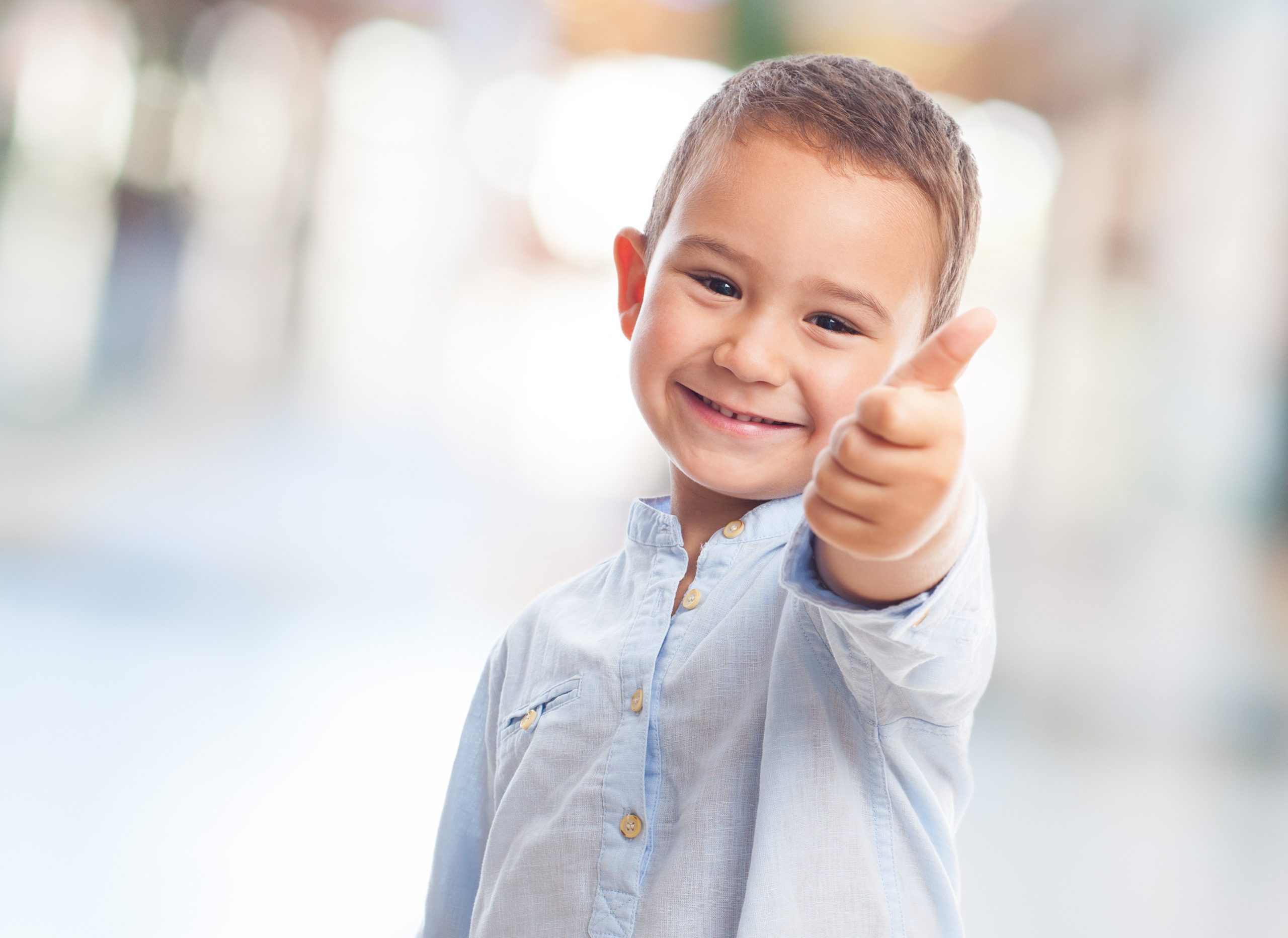 portrait of a little boy doing okay gesture