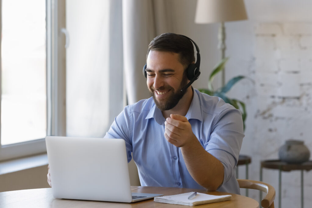 Business or study using modern tech, computer and internet connection, virtual meeting event, online counselling, remote support concept. Young man wear headset sit at desk with laptop work from home