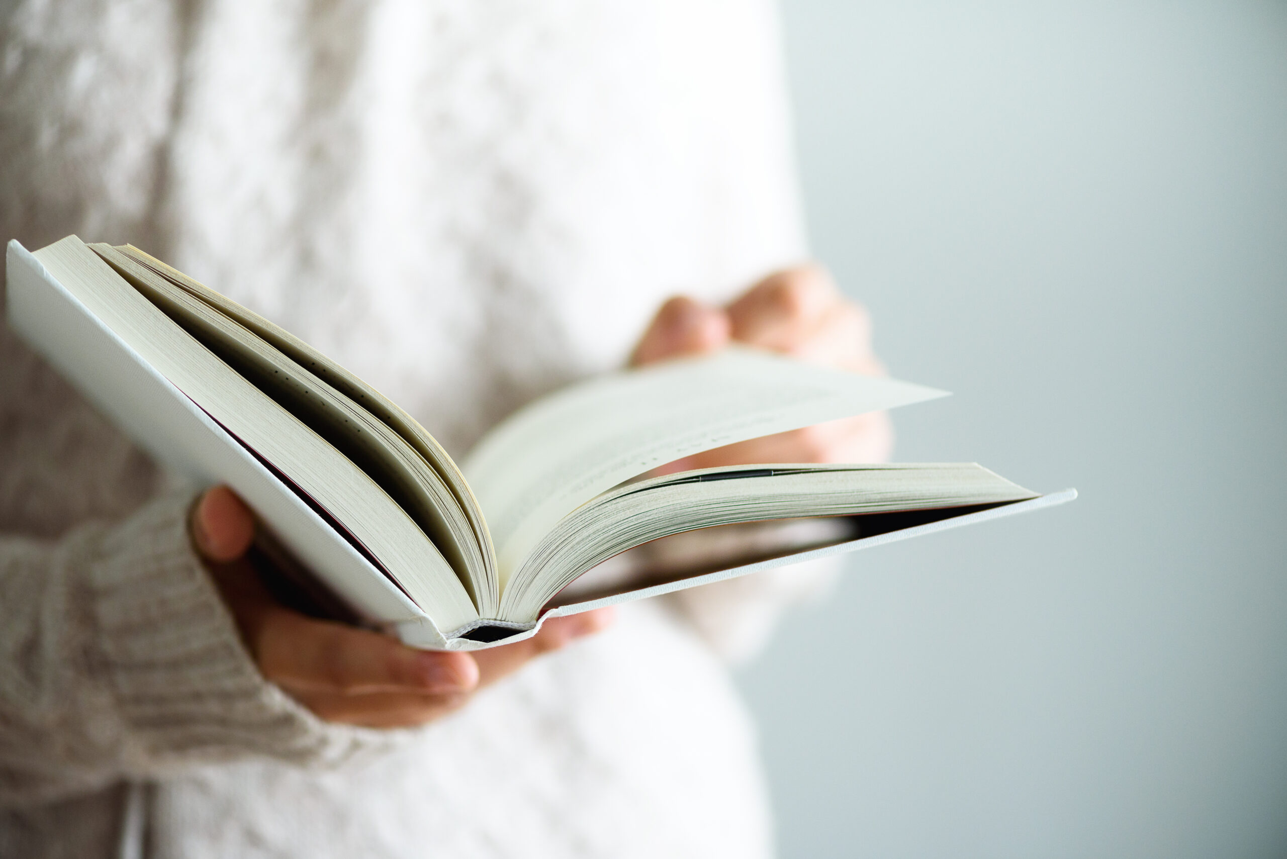 Young girl in white T-shirt reading opened book. Copy space. lifestyle and school concept